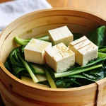 대체 단백질로 만드는 향긋한 찜 요리 - **Steaming Tofu and Vegetables in a Bamboo Steamer:** A close-up, high-angle shot capturing a tradit...