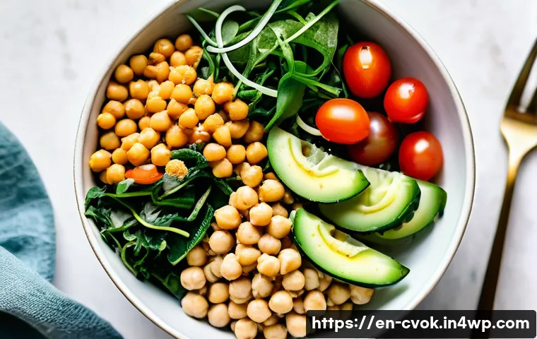 대체 단백질 요리법으로 만드는 간편한 점심 레시피 - A vibrant plant-based power bowl featuring cooked chickpeas tossed with fresh cucumber slices, halve...